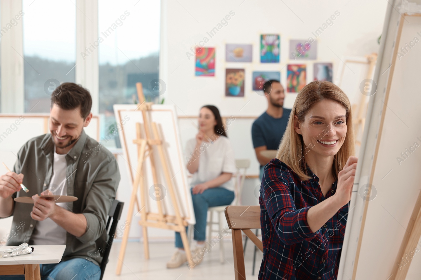 Photo of Group of students attending painting class in studio. Creative hobby