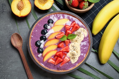 Delicious acai smoothie with fruits served on grey table, flat lay