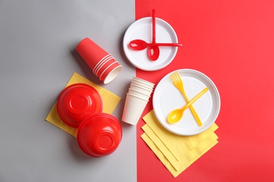 Photo of New plastic dishware on color background. Table setting