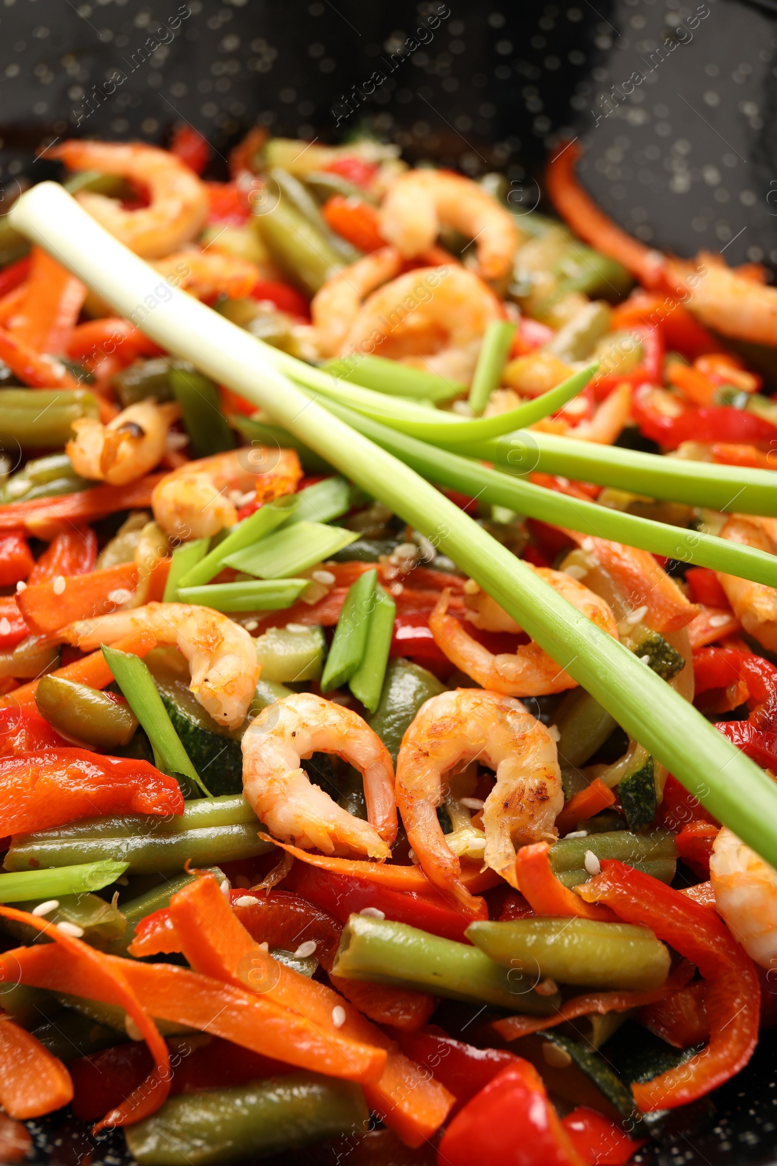 Photo of Shrimp stir fry with vegetables in wok, closeup