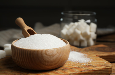 Granulated sugar in bowl on wooden table