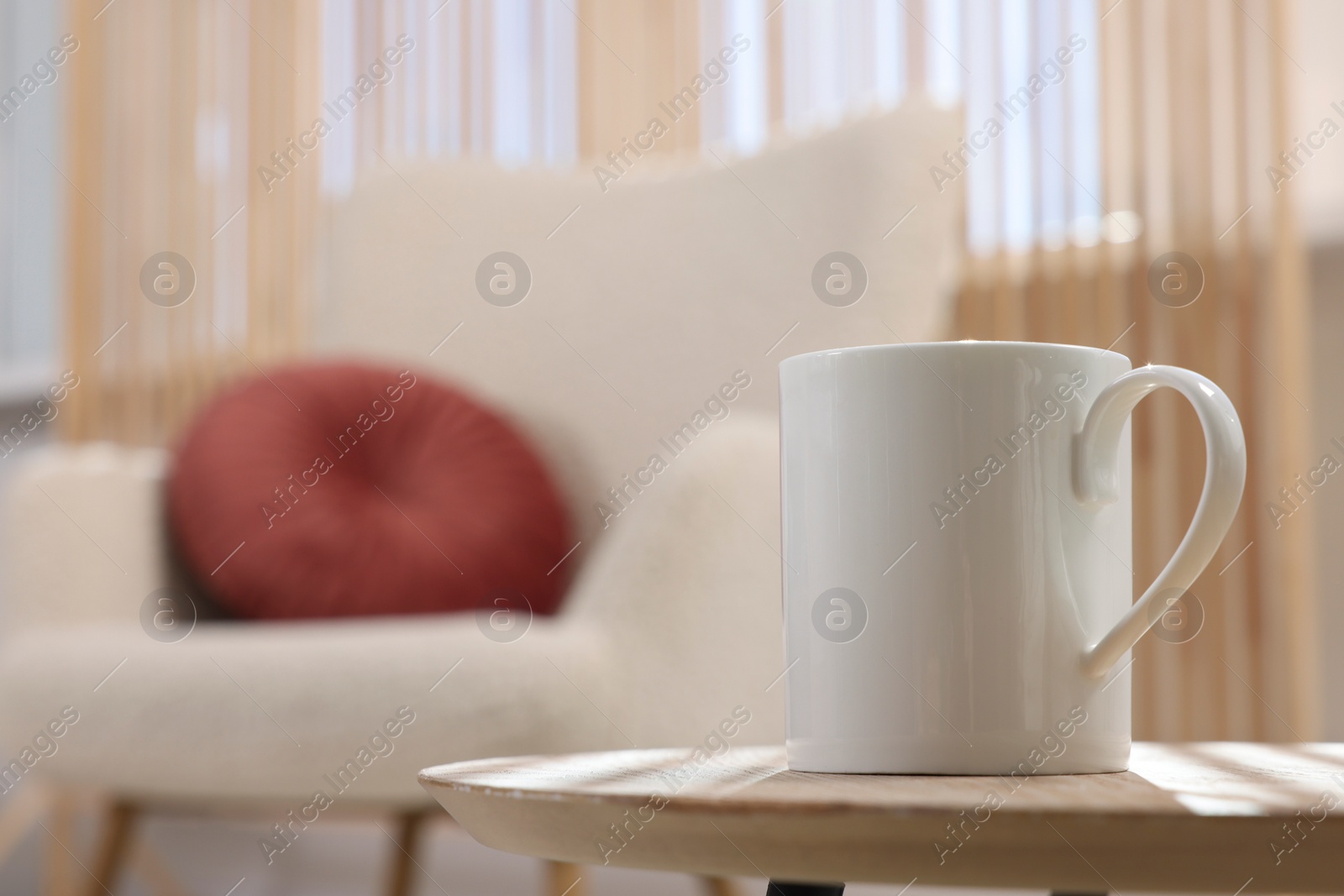 Photo of White mug on wooden table indoors, space for text