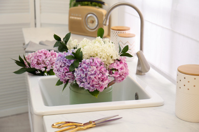 Bouquet with beautiful hydrangea flowers in sink