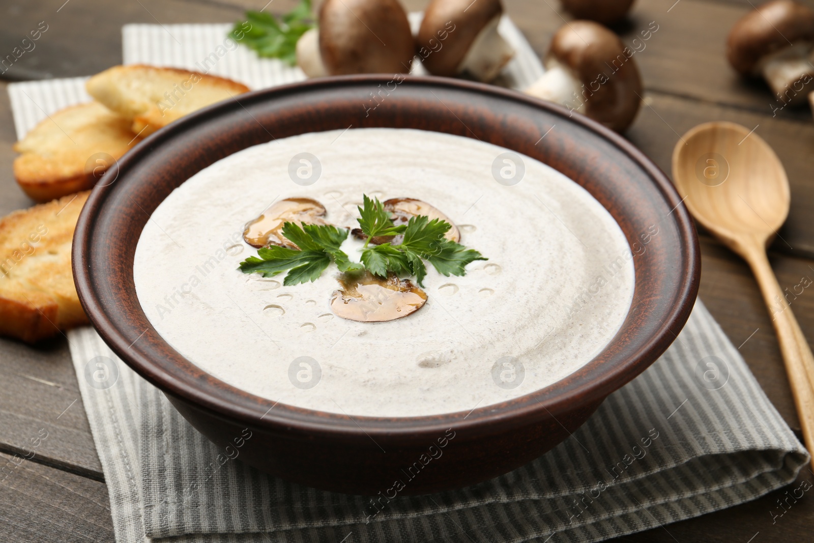 Photo of Fresh homemade mushroom soup served on wooden table