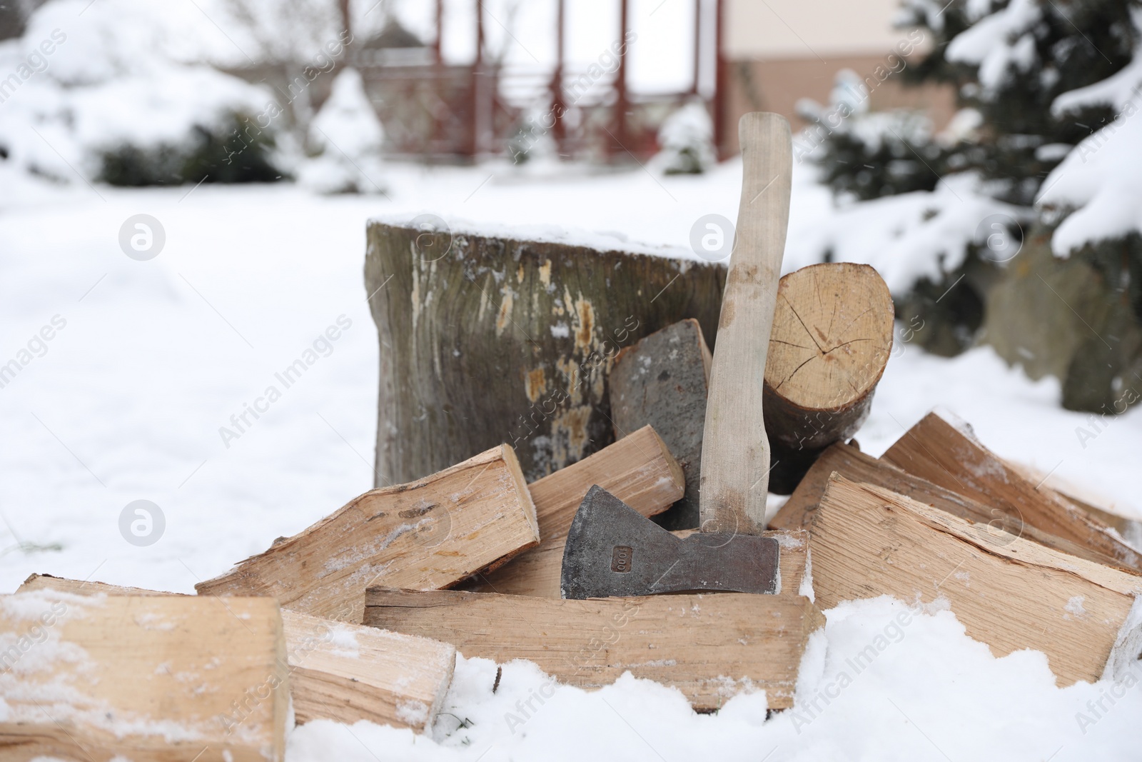 Photo of Axe, chopped wood and wooden log outdoors on winter day