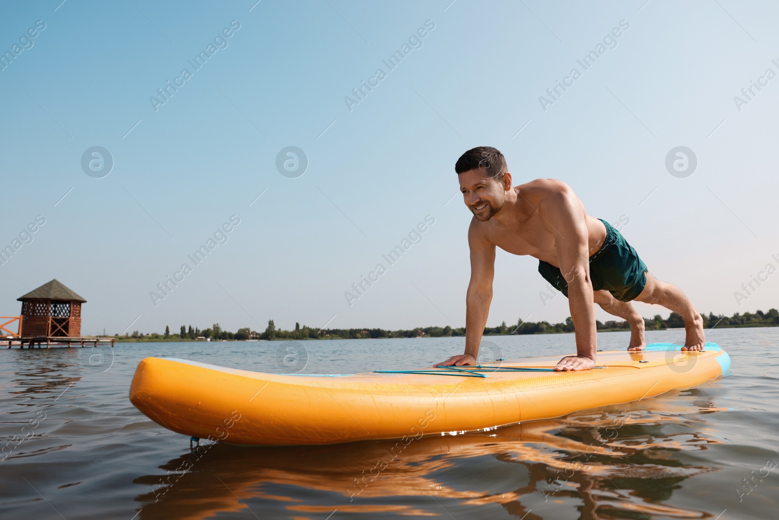 Photo of Man practicing yoga on SUP board on river