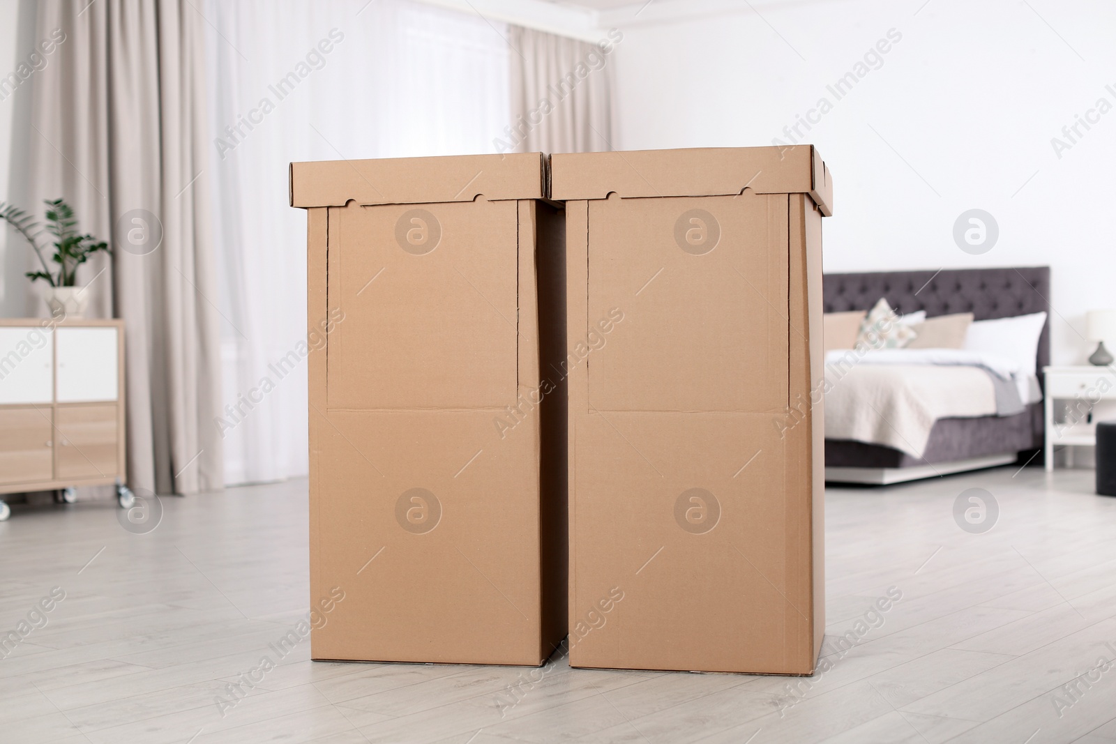 Photo of Cardboard wardrobe boxes in bedroom. Storage idea
