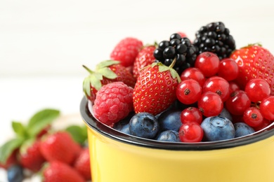 Photo of Mix of ripe berries in mug, closeup