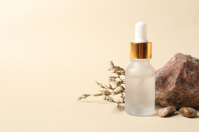 Composition with bottle of cosmetic serum on beige background. Space for text