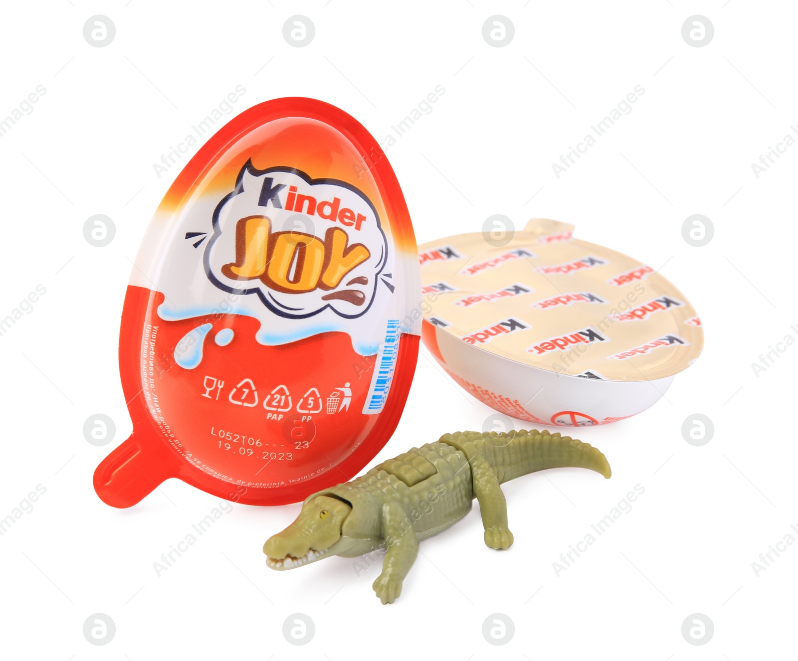 Photo of Slynchev Bryag, Bulgaria - May 24, 2023: Kinder Joy Egg and toy crocodile isolated on white