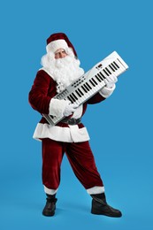 Photo of Santa Claus with synthesizer on blue background. Christmas music
