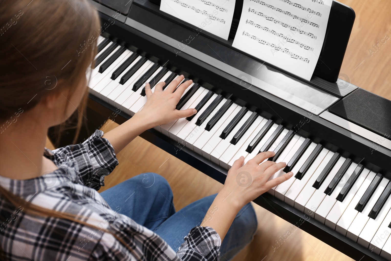 Photo of Young woman playing piano at home, above view