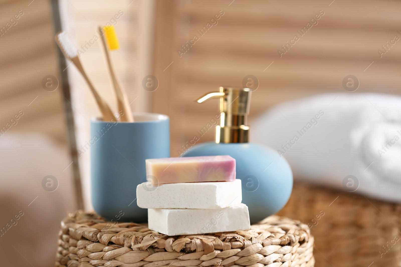 Photo of Composition with soap and toiletries on wicker basket in bathroom