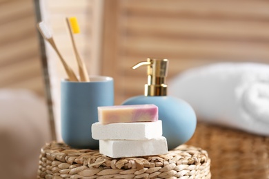 Photo of Composition with soap and toiletries on wicker basket in bathroom