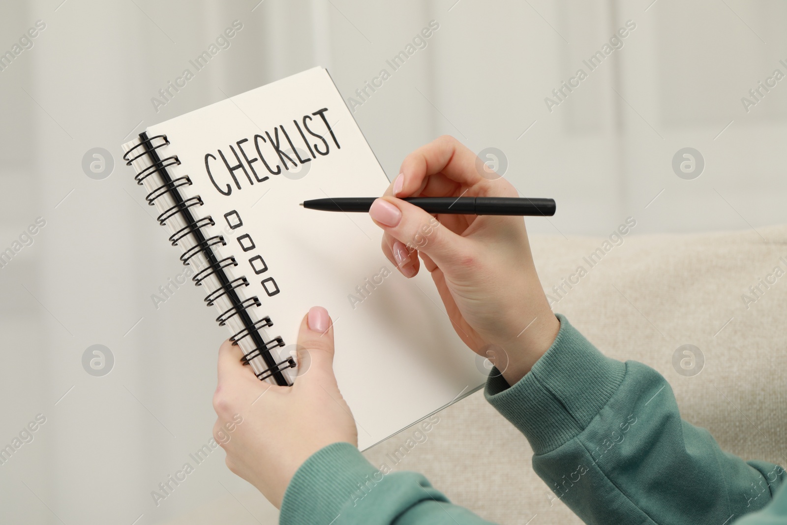 Photo of Woman filling Checklist with pen indoors, closeup