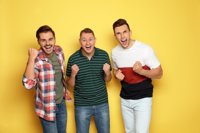 Group of friends laughing together against color background