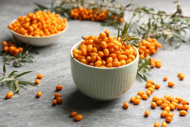 Fresh ripe sea buckthorn in bowl on grey table