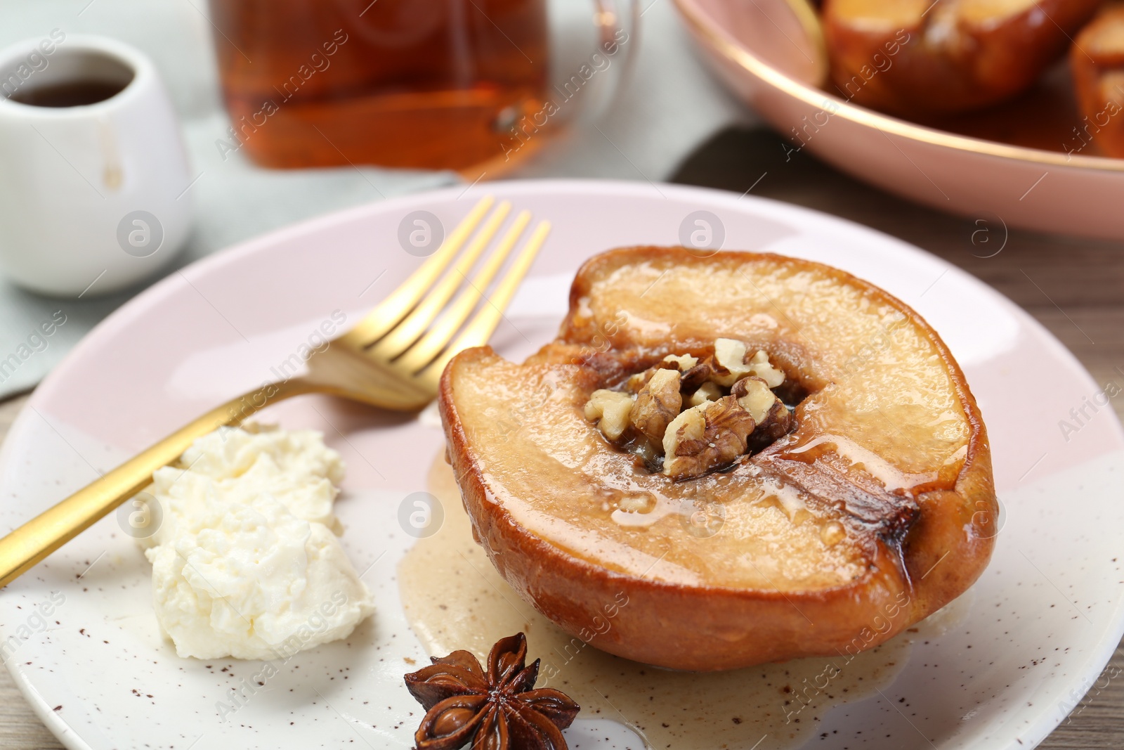 Photo of Delicious quince baked with honey and walnuts on table, closeup