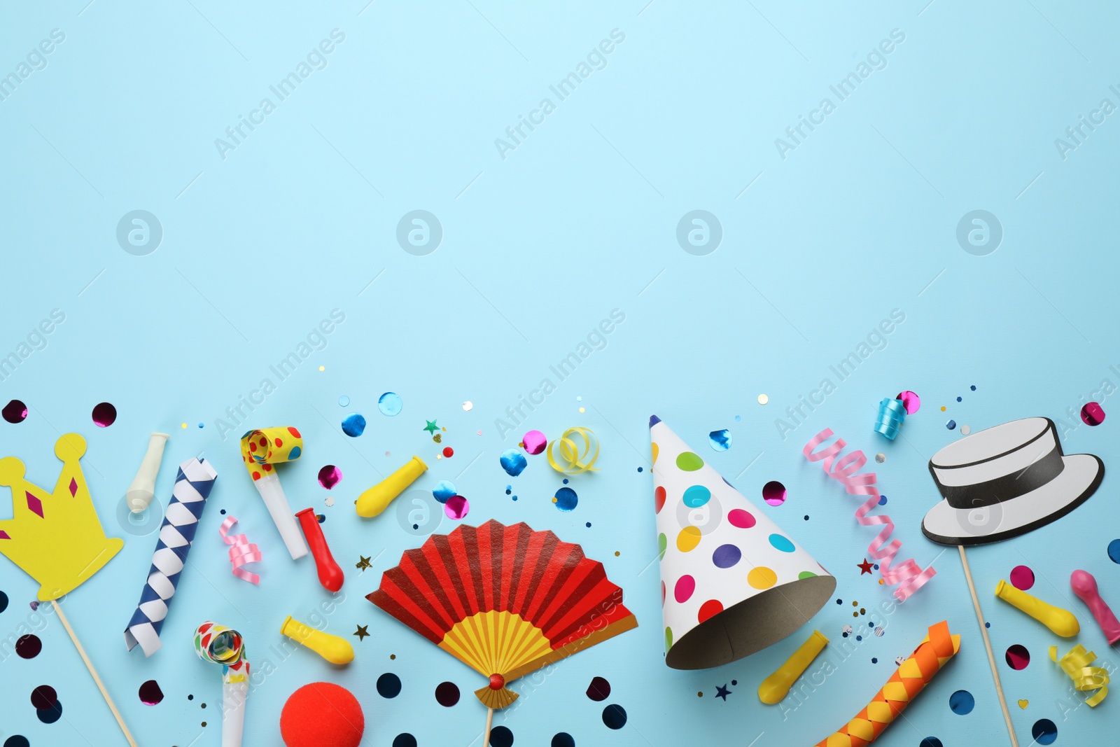 Photo of Flat lay composition with carnival items on light blue background. Space for text