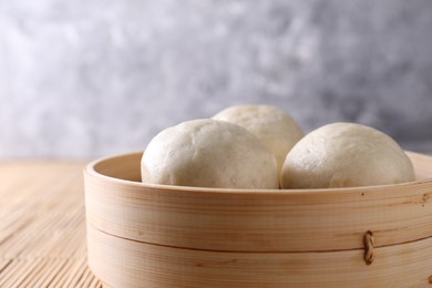 Delicious Chinese steamed buns on bamboo mat, closeup