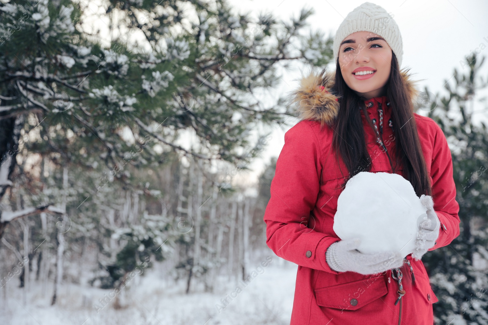 Photo of Young woman holding snowball outdoors on winter day. Space for text