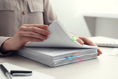 Photo of Woman reading documents at wooden table in office, closeup