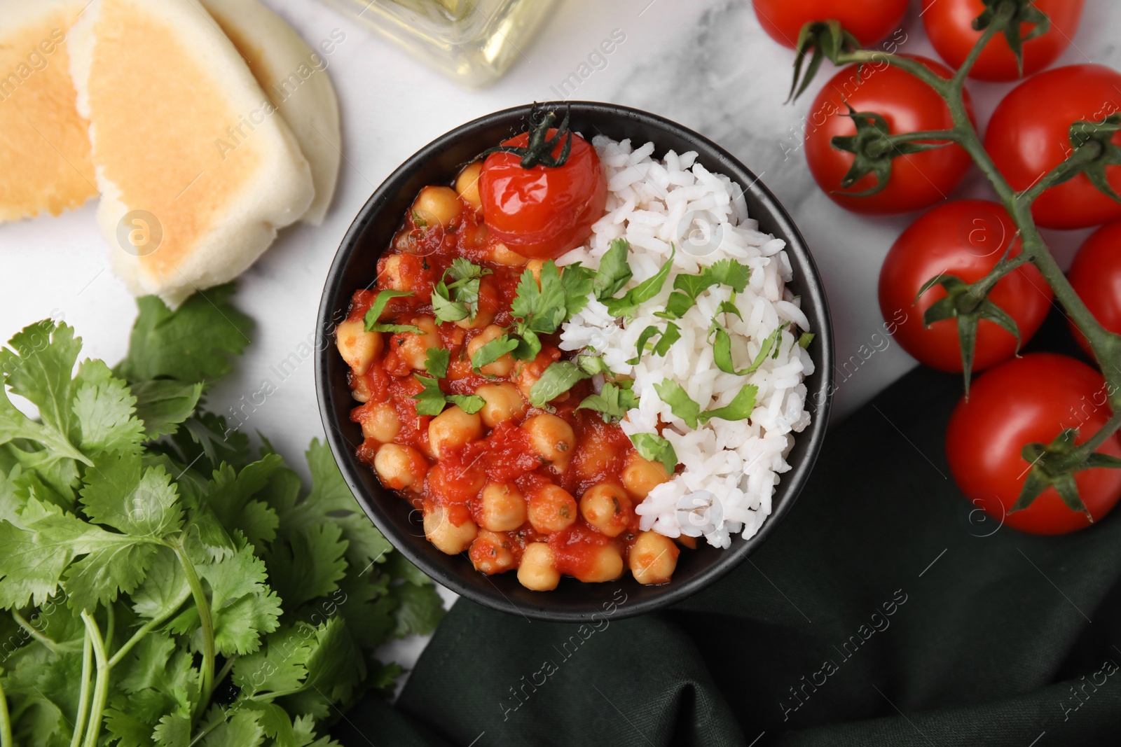 Photo of Delicious chickpea curry in bowl on white marble table, flat lay