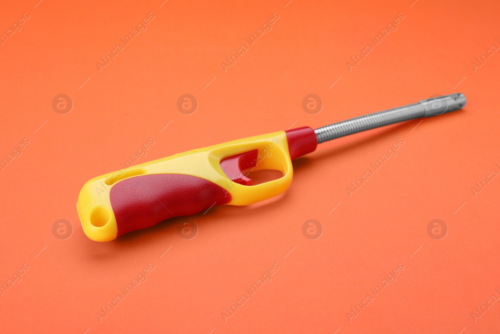 Photo of One bright gas lighter on orange background