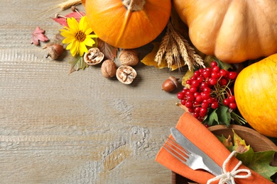 Photo of Autumn vegetables and cutlery on wooden background, flat lay with space for text. Happy Thanksgiving day