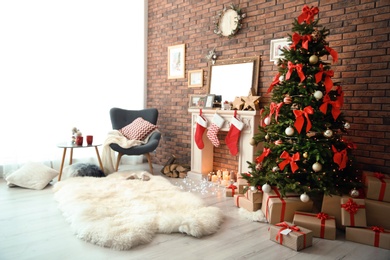 Photo of Room interior with beautiful Christmas tree and gifts near decorative fireplace