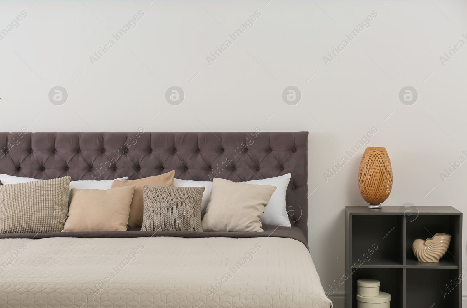 Photo of Large comfortable bed near light wall in modern room interior