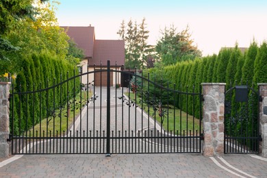 Gates of beautiful stone fence with iron railing outdoors