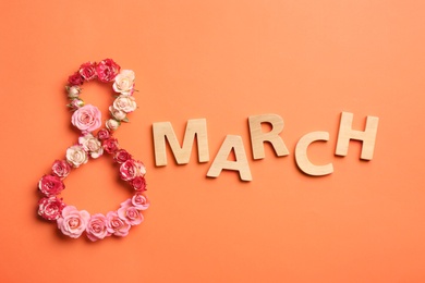 Photo of Phrase "8 March" made of beautiful flowers and wooden letters on color background, top view. Happy Women's Day