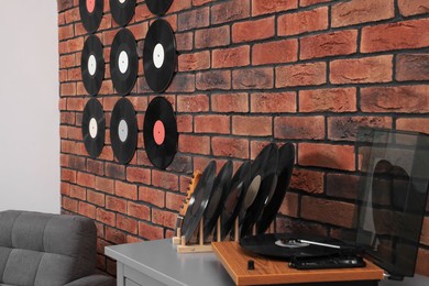 Vinyl records on brick wall and wooden player in living room