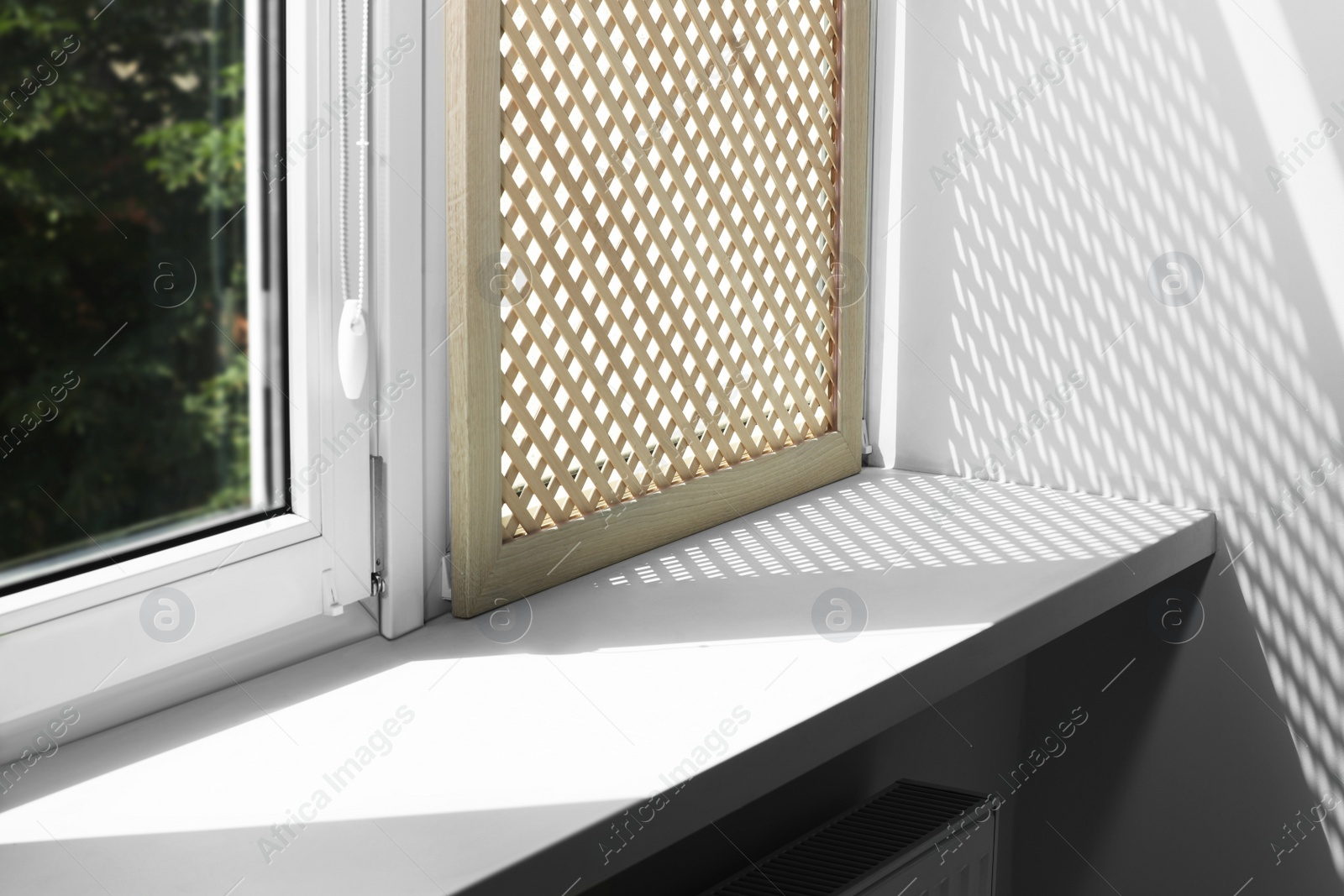 Photo of Empty white window sill and decorative wooden shutter indoors