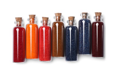 Photo of Glass bottles of different food coloring isolated on white, top view