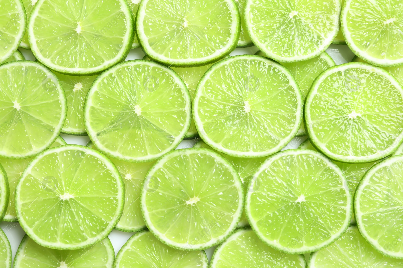 Photo of Fresh sliced ripe limes as background, top view