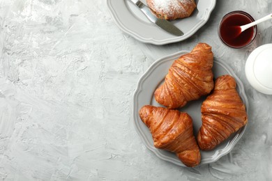 Photo of Flat lay composition with tasty croissants served on light grey textured table. Space for text