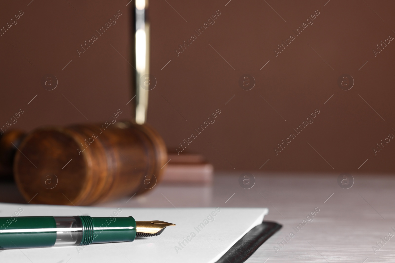 Photo of Fountain pen and paper document on light wooden table, closeup with space for text. Notary service