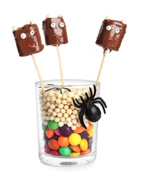 Photo of Delicious candies decorated as monsters on white background. Halloween treat