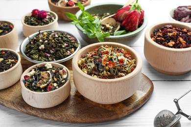 Photo of Many different herbal teas on white wooden table