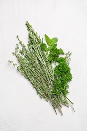 Photo of Fresh rosemary and other herbs on light background, top view