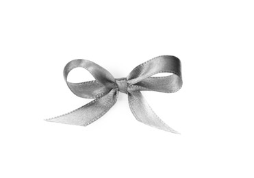 Photo of Silver satin ribbon tied in bow on white background, top view