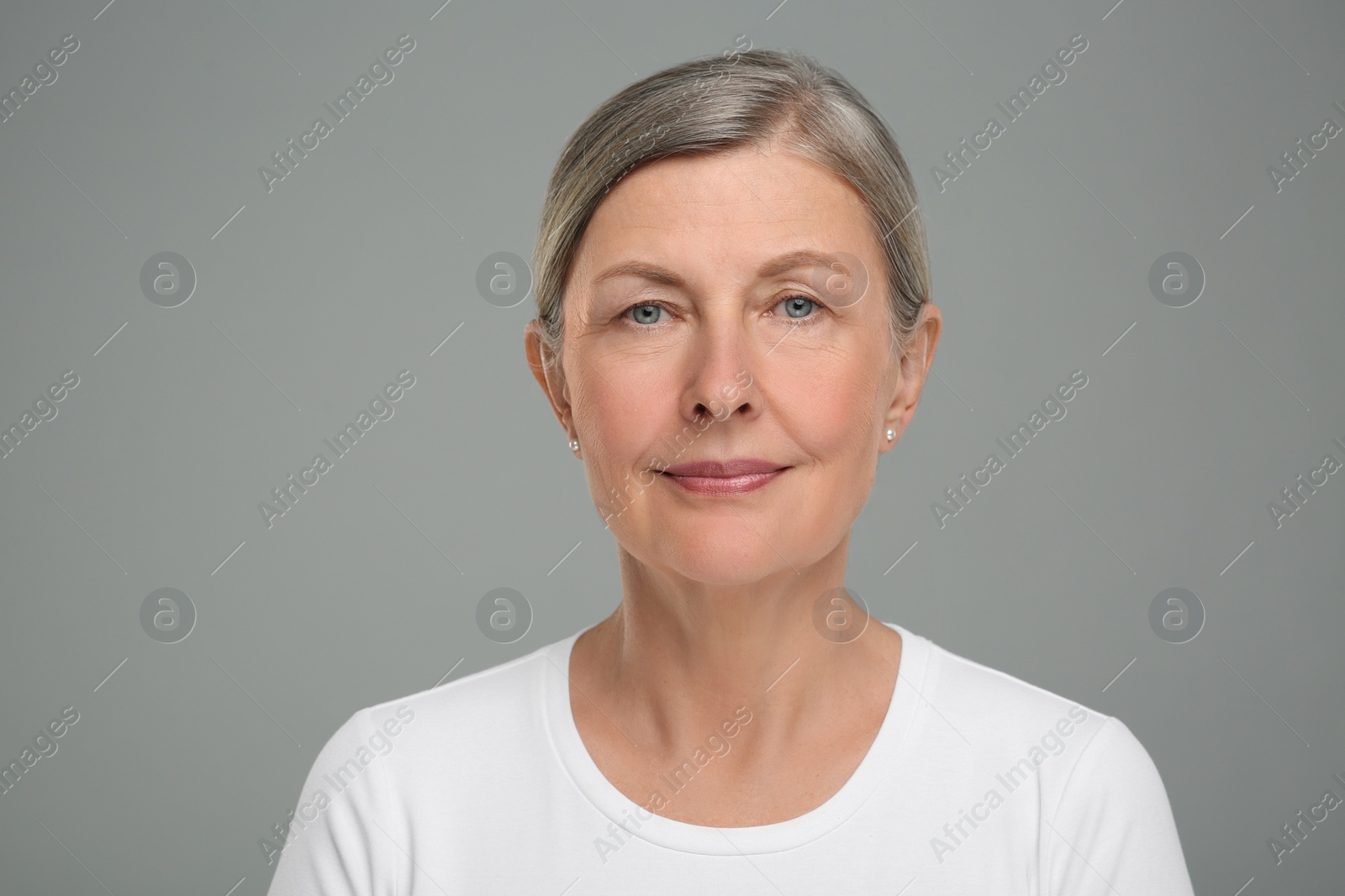 Photo of Portrait of senior woman with aging skin on grey background. Rejuvenation treatment