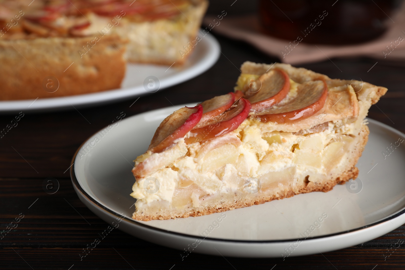 Photo of Piece of delicious homemade apple pie on wooden table, closeup