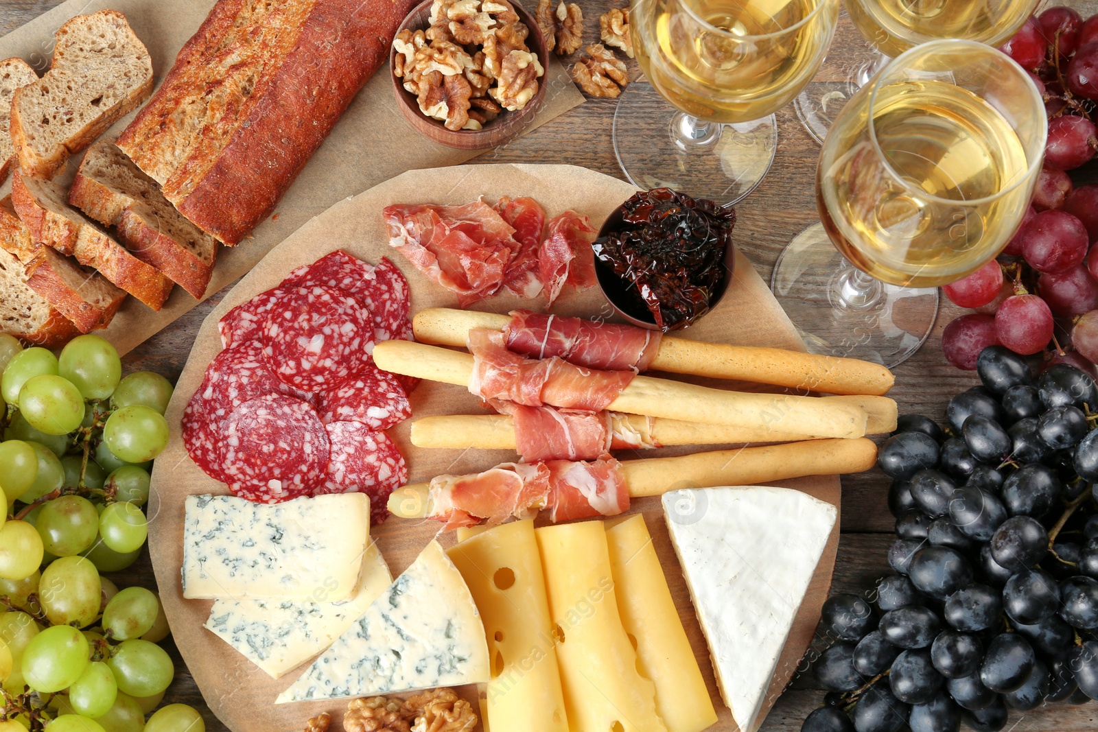 Photo of Flat lay composition with wine and snacks on wooden background