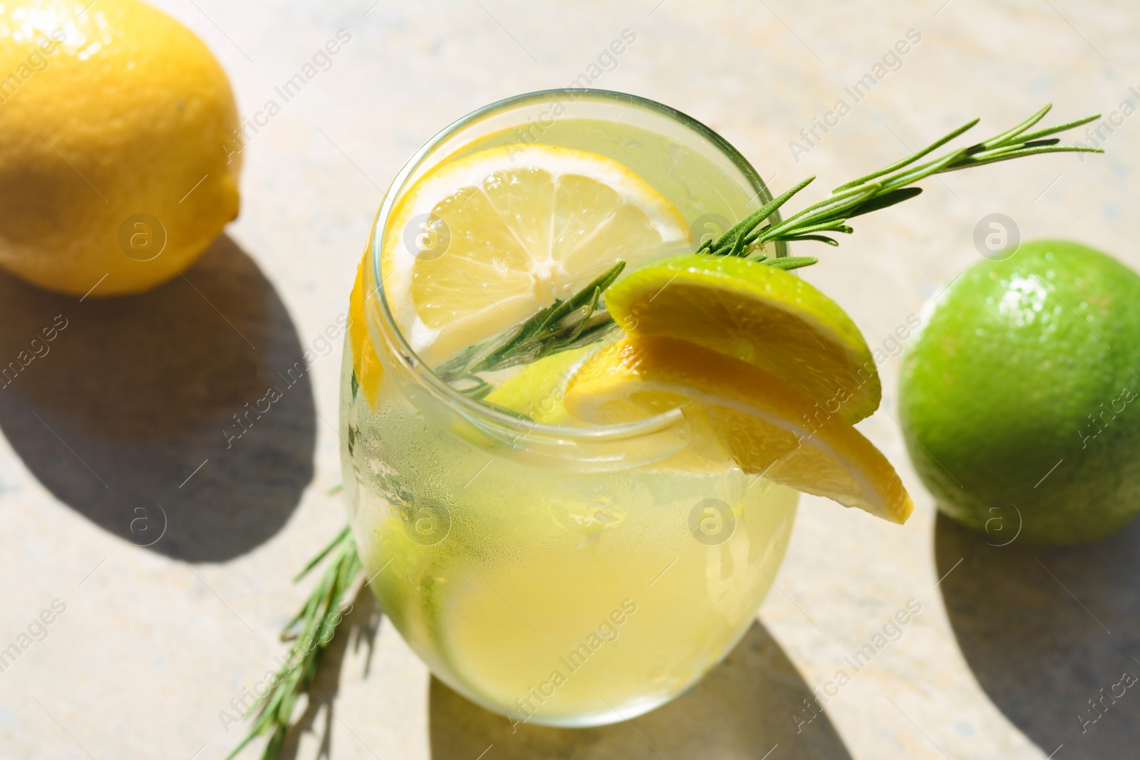 Photo of Tasty refreshing lemonade and ingredients on light table. Summer drink