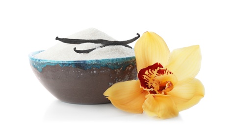 Photo of Vanilla sugar in bowl with flower and sticks on white background