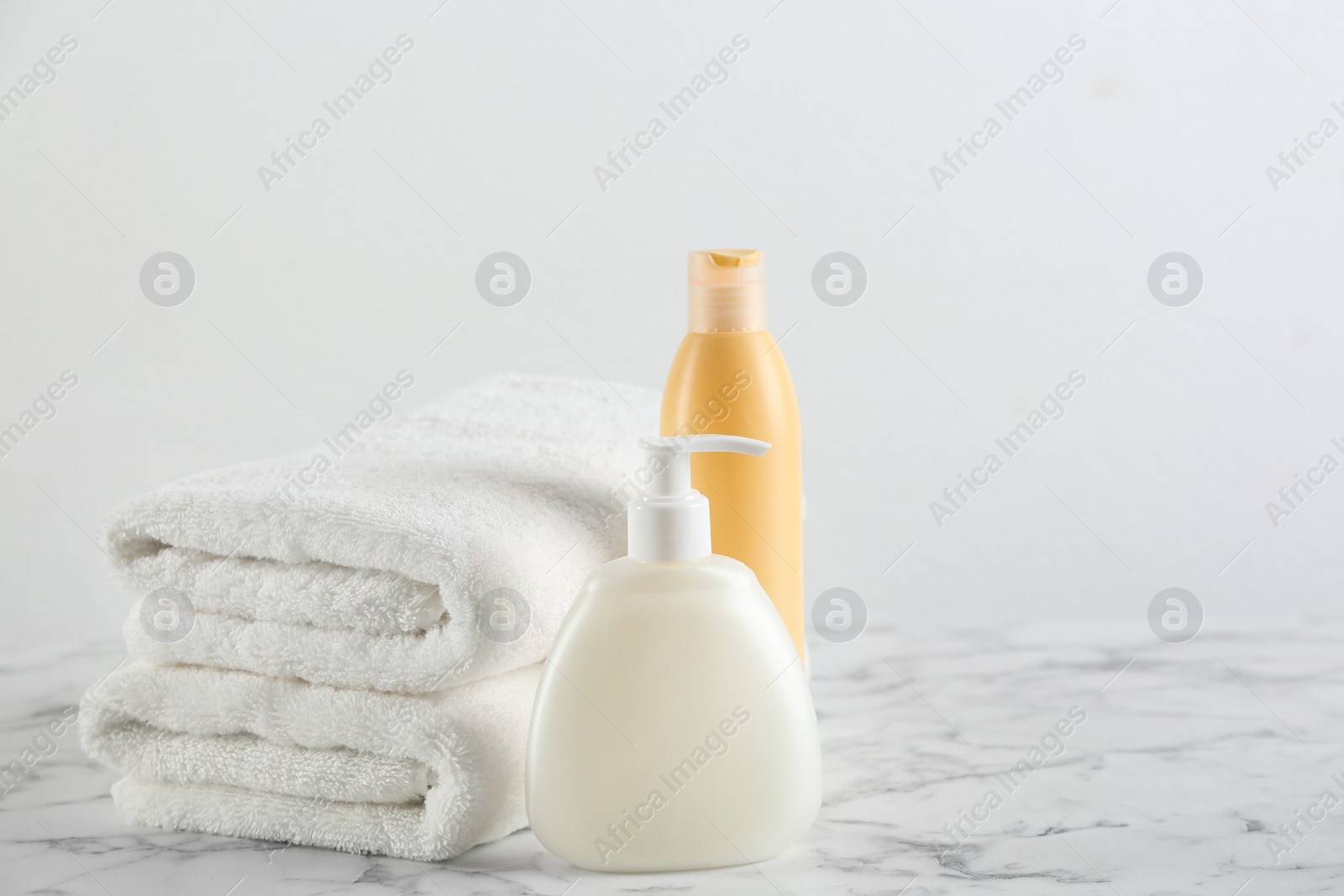 Photo of Fresh towels and toiletries on white marble table. Space for text