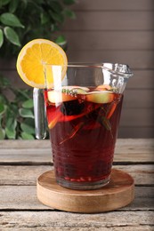 Jug with delicious refreshing sangria on old wooden table